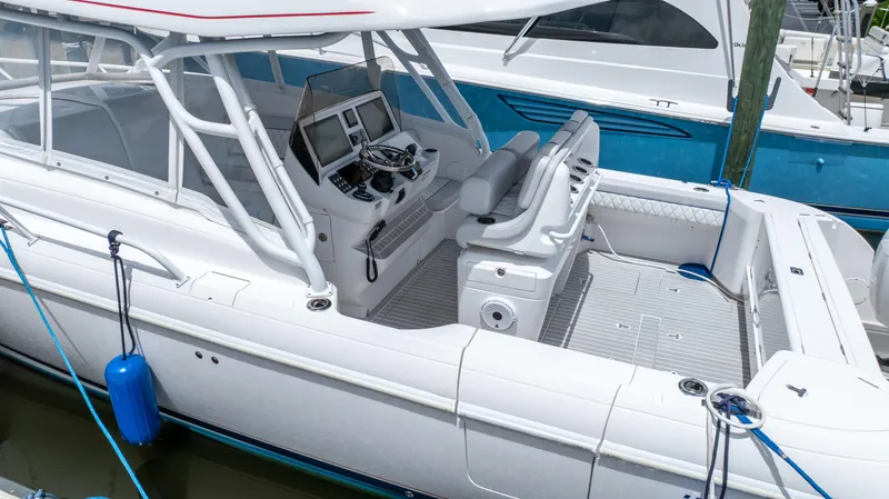 Slide: The Image of 2022 Intrepid 345 Valor boat with sleek design and modern cockpit, docked in marina. - 30