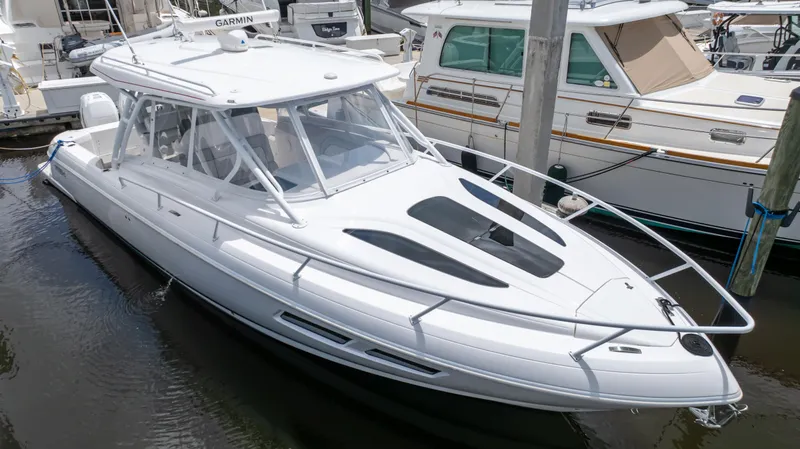 Slide: The Image of 2022 Intrepid 345 Valor boat docked in marina, sleek white design, modern features. - 32