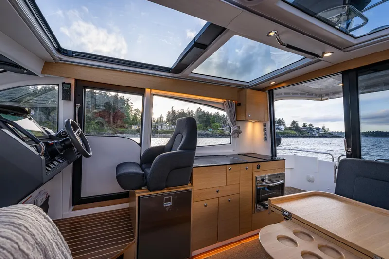 Slide: The Image of Interior of 2022 Nimbus 365 Coupe boat with panoramic windows and modern design. - 10
