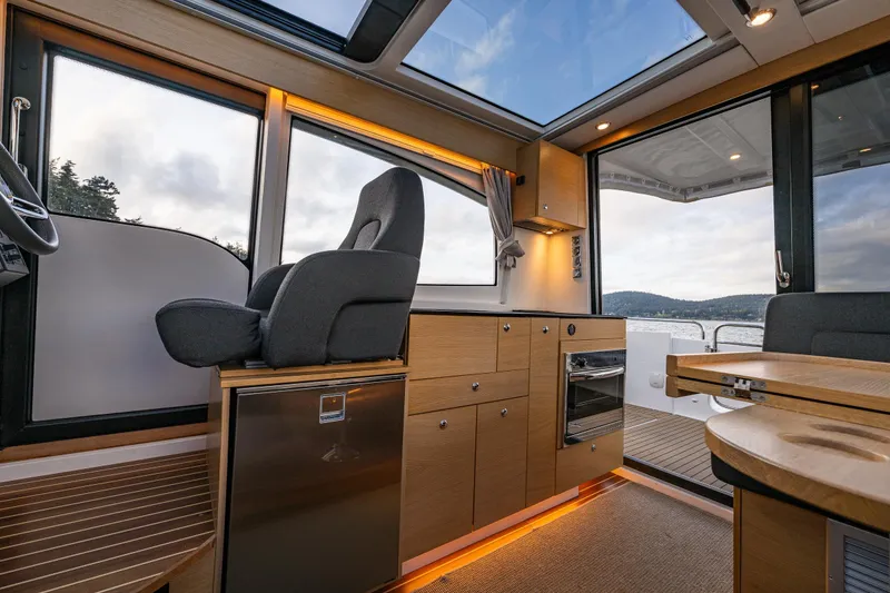 Slide: The Image of Interior of 2022 Nimbus 365 Coupe boat with modern kitchen and seating area. - 11