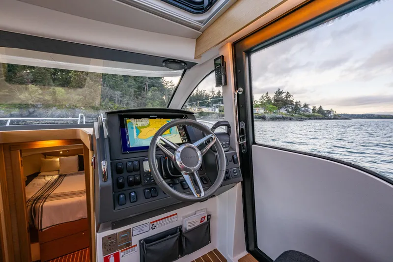 Slide: The Image of Interior view of 2022 Nimbus 365 Coupe boat with steering wheel and navigation system. - 13