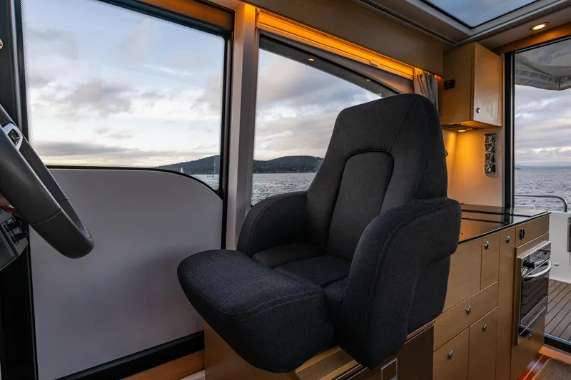 Slide: The Image of Interior of 2022 Nimbus 365 Coupe boat with luxurious seating and scenic ocean view. - 14