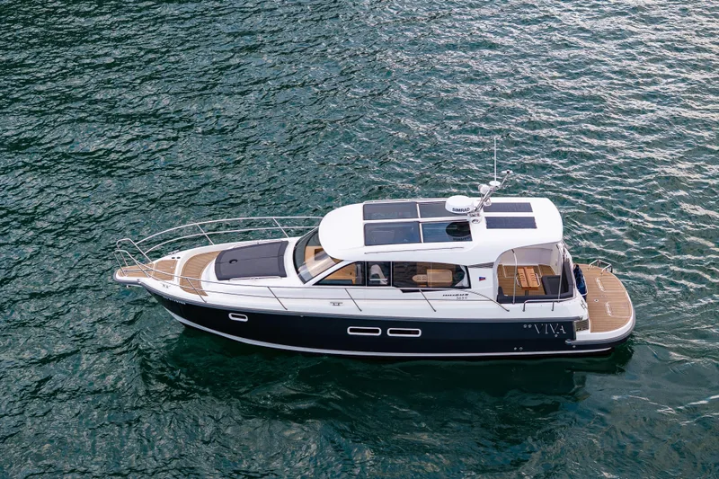 Slide: The Image of 2022 Nimbus 365 Coupe yacht cruising on open water. - 2