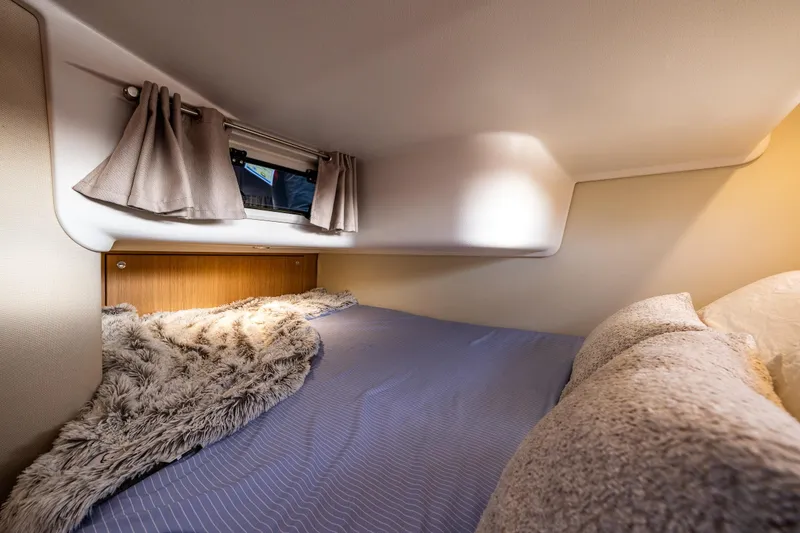 Slide: The Image of Cozy cabin interior of 2022 Nimbus 365 Coupe with plush bedding and window curtains. - 21