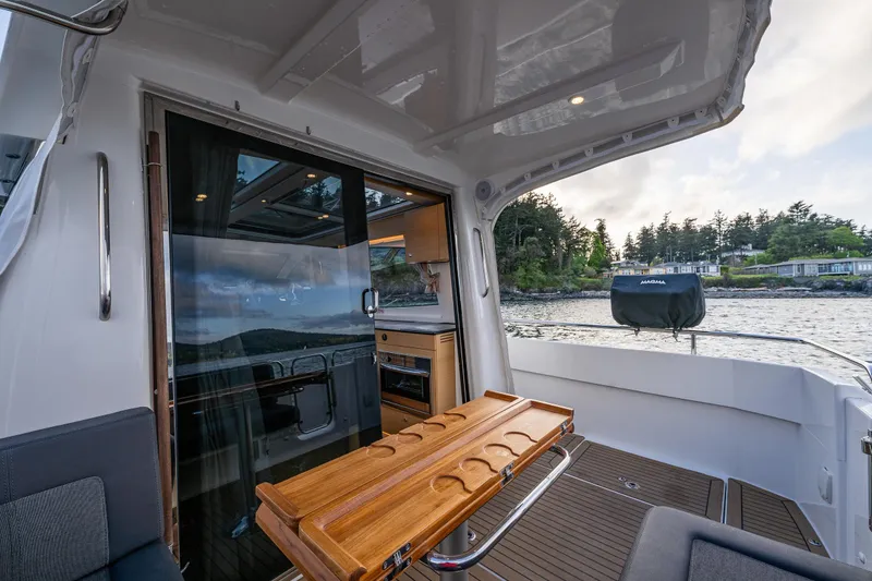 Slide: The Image of Nimbus 365 Coupe 2022 yacht interior with wooden table and scenic water view. - 22