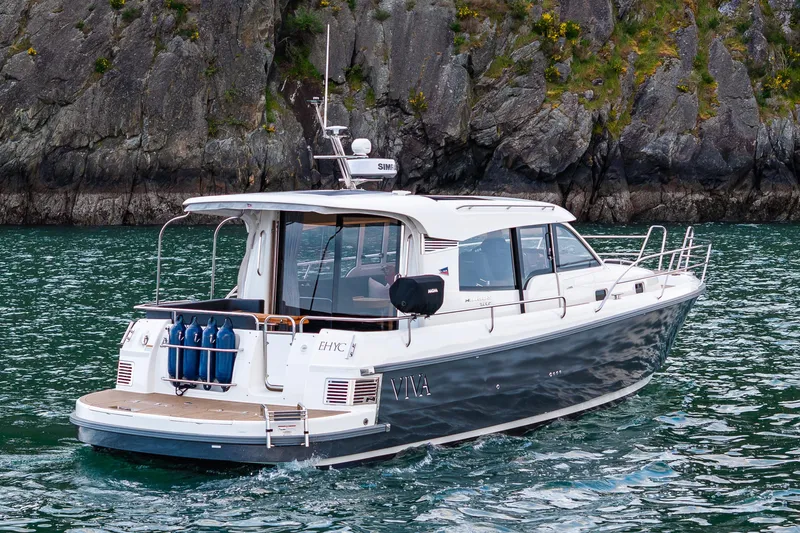 Slide: The Image of 2022 Nimbus 365 Coupe cruising near rocky shoreline in clear waters. - 28