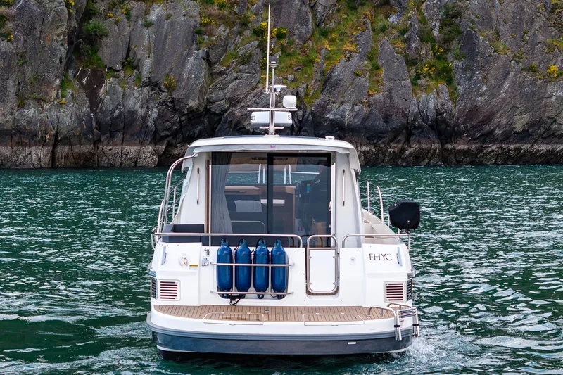 Slide: The Image of Nimbus 365 Coupe 2022 boat cruising near rocky shoreline. - 29
