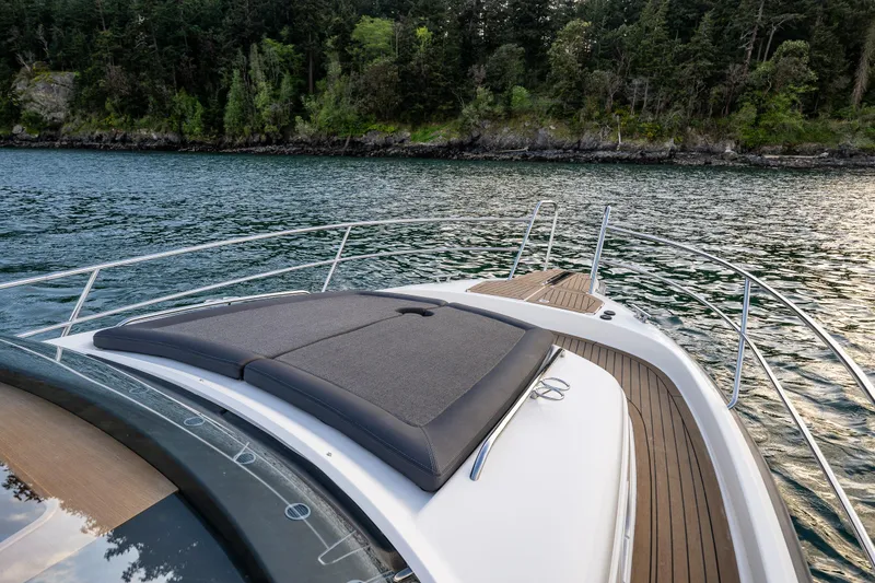 Slide: The Image of Luxury Nimbus 365 Coupe 2022 yacht cruising near a forested shoreline. - 36