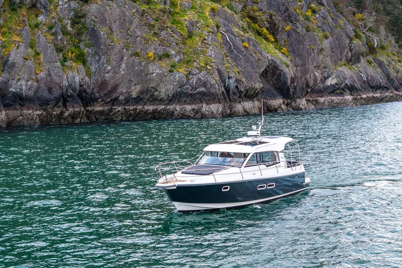 Slide: The Image of 2022 Nimbus 365 Coupe cruising near rocky shoreline in clear waters. - 41