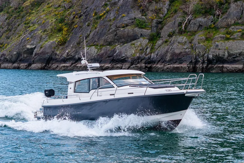 Slide: The Image of Nimbus 365 Coupe 2022 cruising on water near rocky shoreline. - 44