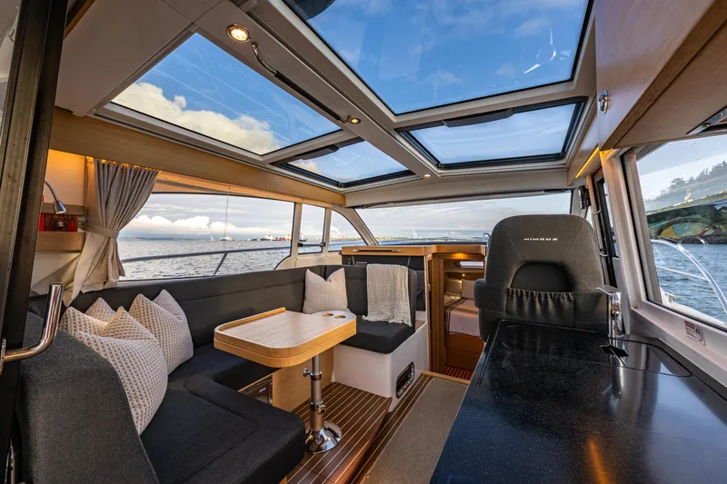 Slide: The Image of Interior of 2022 Nimbus 365 Coupe yacht with panoramic windows and elegant seating area. - 5