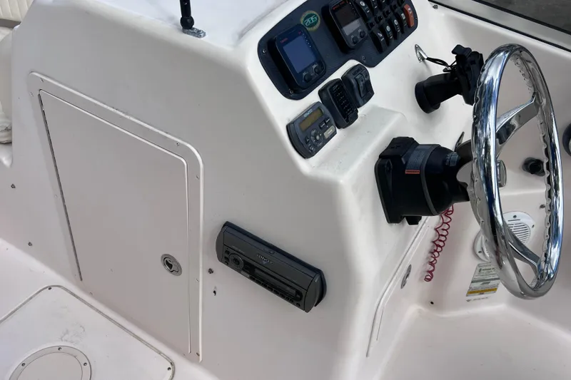 Slide: The Image of 2006 Grady-White Tournament 205 boat dashboard with steering wheel and control panel. - 23