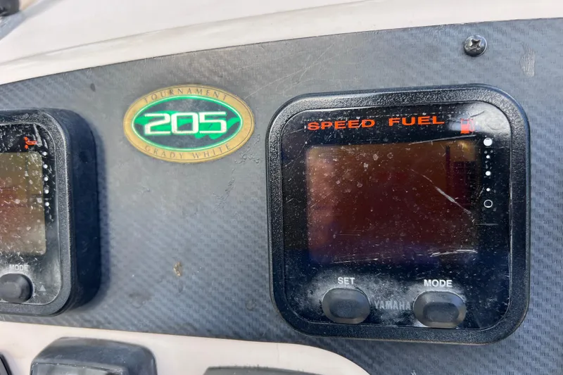 Slide: The Image of Dashboard of a 2006 Grady-White Tournament 205 boat with speed and fuel gauges. - 34
