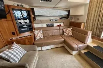 Slide: The Image of 2002 Carver 350 Mariner interior with beige seating, patterned cushions, and wood accents. - 13