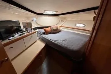 Slide: The Image of 2002 Carver 350 Mariner cabin interior with bed, TV, and storage. - 5