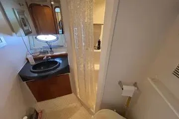 Slide: The Image of 2002 Carver 350 Mariner bathroom with sink, mirror, and shower curtain. - 8