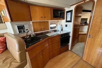 Slide: The Image of 2002 Carver 350 Mariner yacht interior with kitchen, featuring wood cabinetry and modern appliances. - 9