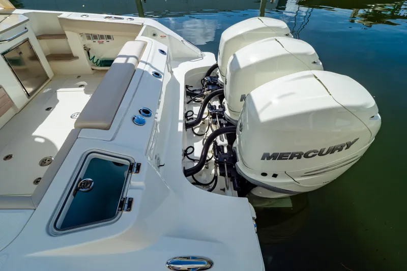 Slide: The Image of 2019 Boston Whaler 350 Realm with triple Mercury outboard engines docked on water. - 6