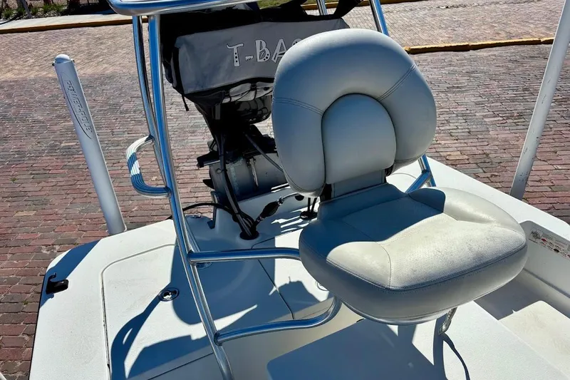 Slide: The Image of 2009 Ranger Banshee boat with cushioned seat and steering console on brick pavement. - 13
