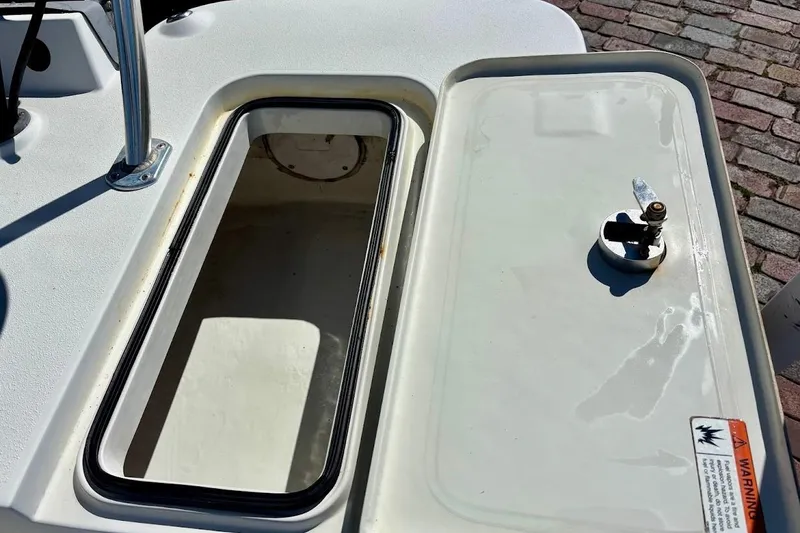 Slide: The Image of Open storage compartment on a 2009 Ranger Banshee boat, showing interior and latch. - 18