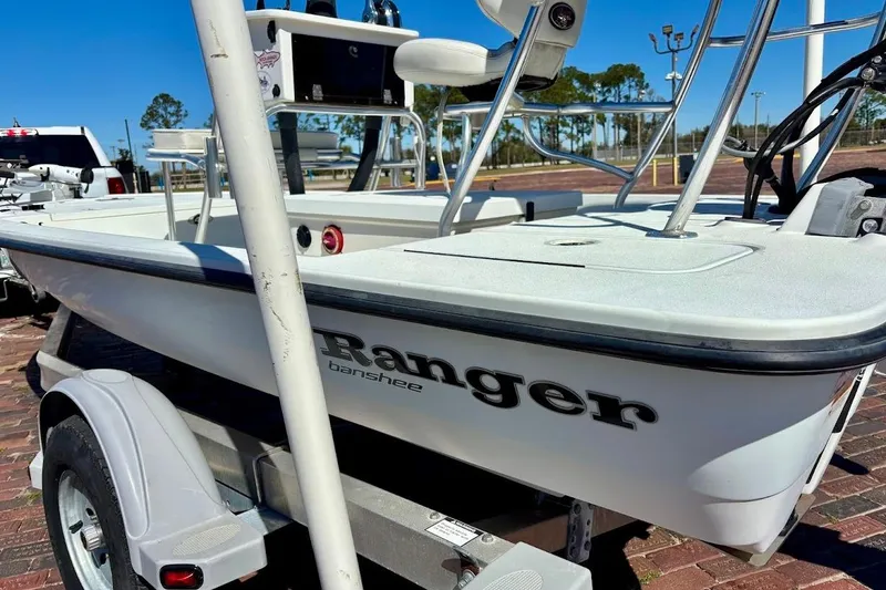 Slide: The Image of 2009 Ranger Banshee boat on trailer, parked outdoors under clear blue sky. - 8