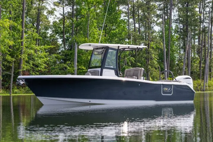 Slide: The Image of Manufacturer Provided Image: 2025 Sea Hunt Ultra 255 SE boat interior with open storage compartments on a lake. - 25