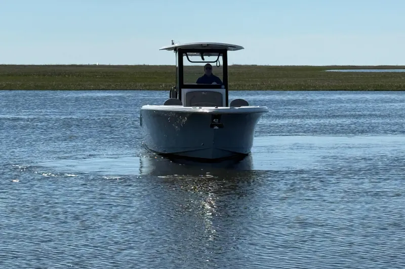 Slide: The Image of 2025 Sea Hunt Ultra 255 SE boat cruising on calm water under clear sky. - 3