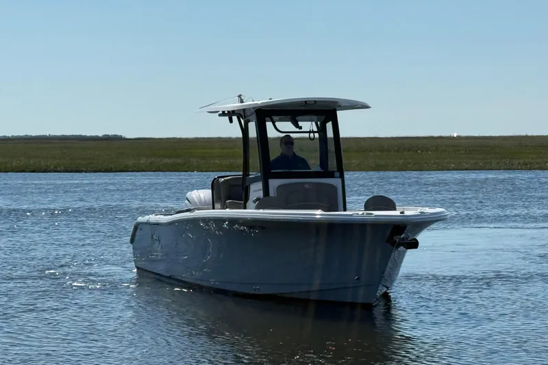 Slide: The Image of 2025 Sea Hunt Ultra 255 SE boat cruising on calm water under clear sky. - 4