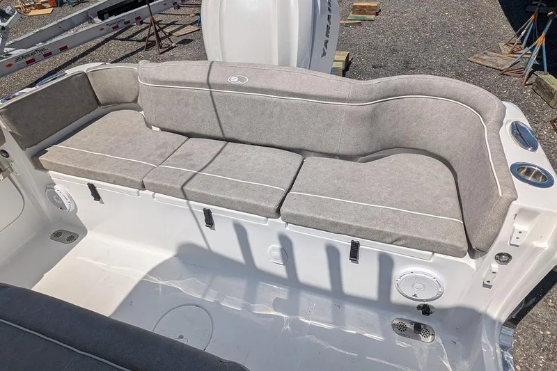 Slide: The Image of 2025 Sea Hunt Ultra 255 SE boat interior with open storage compartment and cushioned seating. - 6