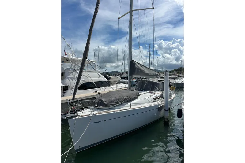 The Image of 2011 Jeanneau Sun Odyssey 44i sailboat docked in a marina under cloudy skies. - 0