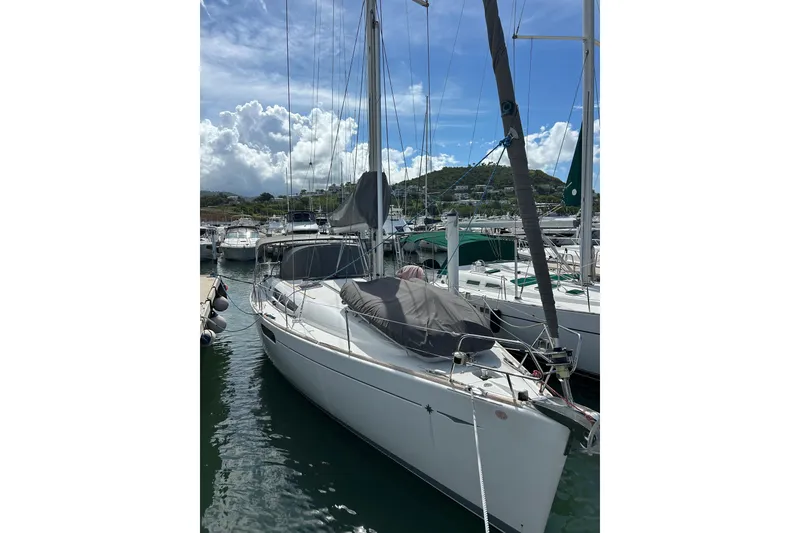 Slide: The Image of 2011 Jeanneau Sun Odyssey 44i sailboat docked at marina under cloudy sky. - 2