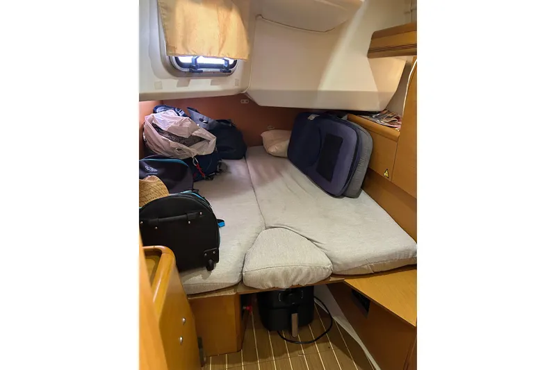 Slide: The Image of Cabin interior of 2011 Jeanneau Sun Odyssey 44i with cluttered storage and bedding. - 31