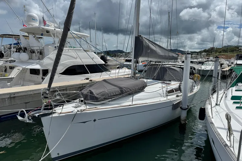 Slide: The Image of 2011 Jeanneau Sun Odyssey 44i sailboat docked at marina under cloudy sky. - 44