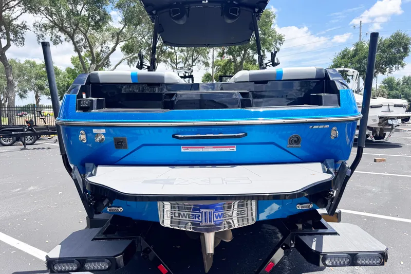 Slide: The Image of 2025 Axis A245 boat, blue exterior, parked outdoors under a clear sky. - 4