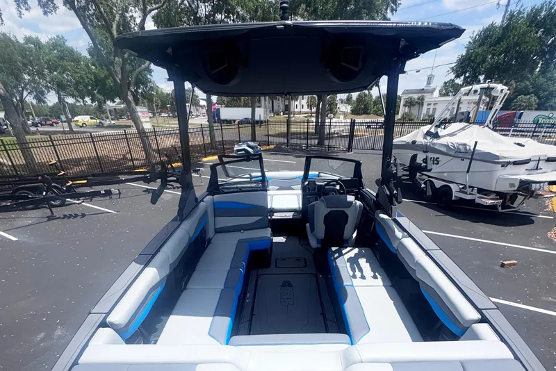 Slide: The Image of 2025 Axis A245 boat interior with spacious seating and modern design in a parking lot. - 5