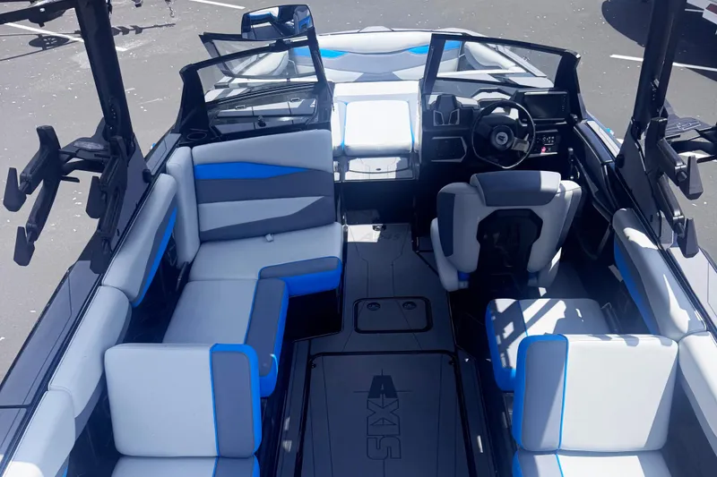 Slide: The Image of 2025 Axis A245 boat interior with modern seating and steering wheel, featuring blue and gray accents. - 6