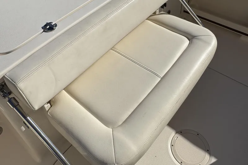 Slide: The Image of 2017 Grady-White Fisherman 257 boat seat, featuring white cushioned upholstery and stainless steel hardware. - 15