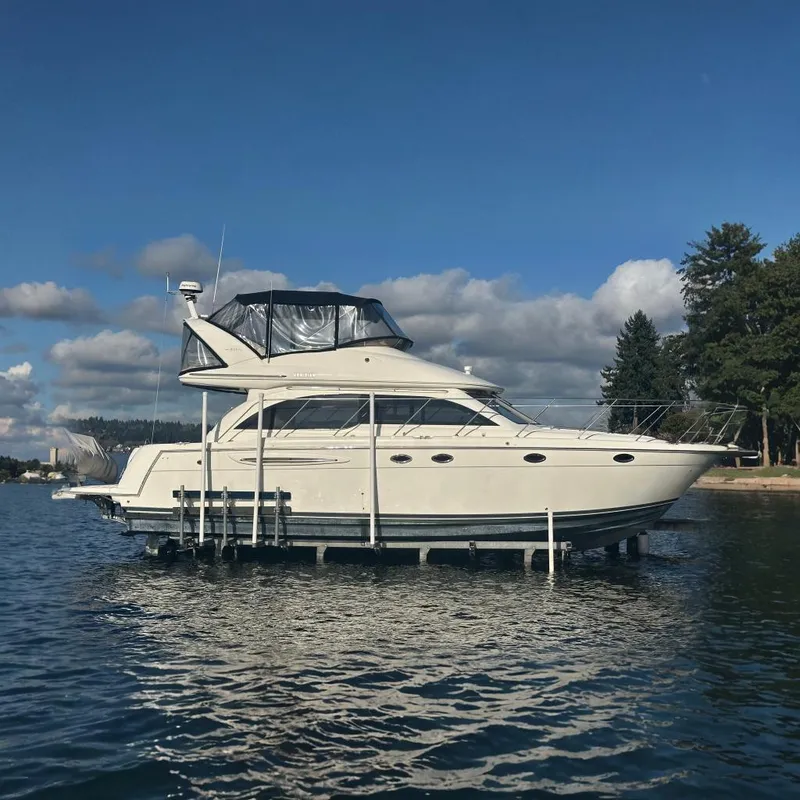 The Image of 2006 Meridian 411 Sedan yacht on a lift, with a scenic water backdrop. - 0