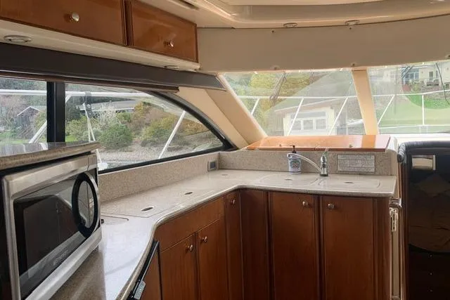 Slide: The Image of Interior of a 2006 Meridian 411 Sedan yacht with wooden cabinetry and modern appliances. - 46