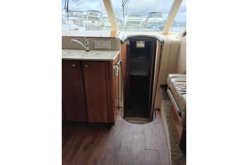 Slide: The Image of Interior of 2006 Meridian 411 Sedan yacht, featuring a compact kitchenette and seating area. - 49