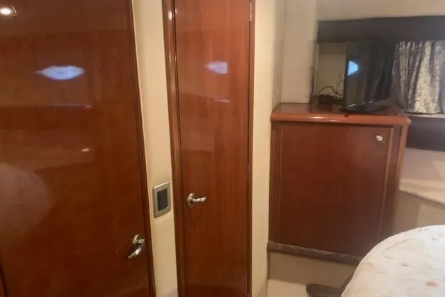 Slide: The Image of Interior of a 2006 Meridian 411 Sedan yacht with wooden cabinetry and a small TV. - 54