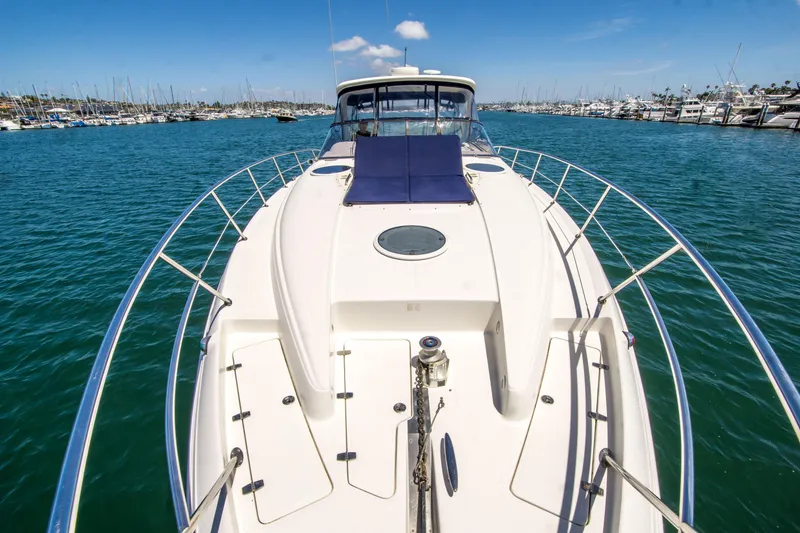 Slide: The Image of 2003 Regal Commodore 4260 yacht on calm blue water, marina in background. - 5