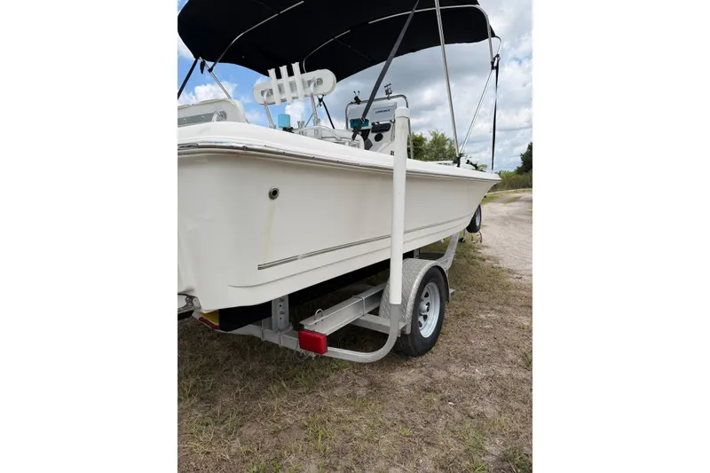 Slide: The Image of 2016 Bulls Bay 2000 boat on trailer with canopy, parked on grassy area. - 10