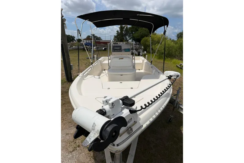 Slide: The Image of 2016 Bulls Bay 2000 boat with canopy and trolling motor, parked on a trailer. - 2