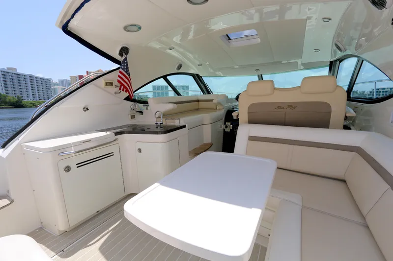 Slide: The Image of Luxurious 2013 Searay 41 yacht interior with seating, kitchenette, and American flag. - 5