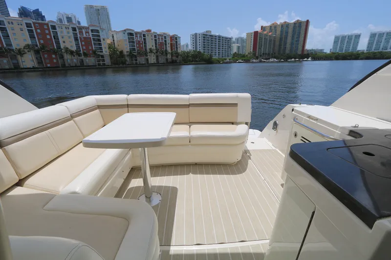 Slide: The Image of Luxurious 2013 Searay 41 yacht deck with seating, table, and waterfront city view. - 6