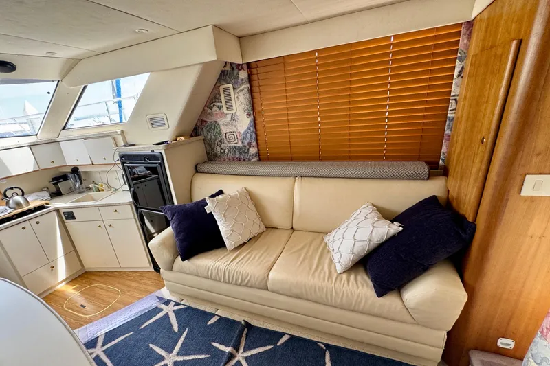 Slide: The Image of Interior of a 1999 Silverton 351 Sedan yacht with cozy seating and kitchen area. - 11