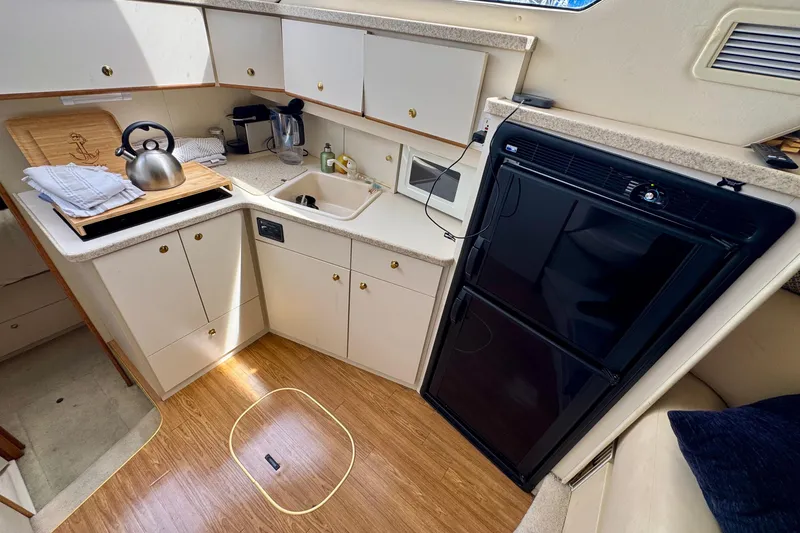 Slide: The Image of 1999 Silverton 351 Sedan yacht kitchen with modern appliances and wooden flooring. - 14