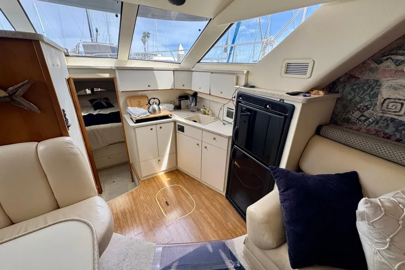 Slide: The Image of Interior of a 1999 Silverton 351 Sedan yacht, featuring a cozy kitchen and seating area. - 17