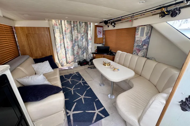 Slide: The Image of Interior of a 1999 Silverton 351 Sedan yacht with cozy seating and fishing rods. - 19